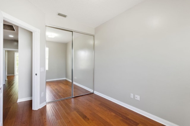 155 Waterford Dr, Jupiter, FL 33458 - unfurnished bedroom featuring wood finished floors, baseboards, and a closet