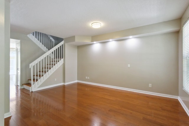 155 Waterford Dr, Jupiter, FL 33458 - below grade area with wood finished floors, stairway, baseboards, and a textured ceiling