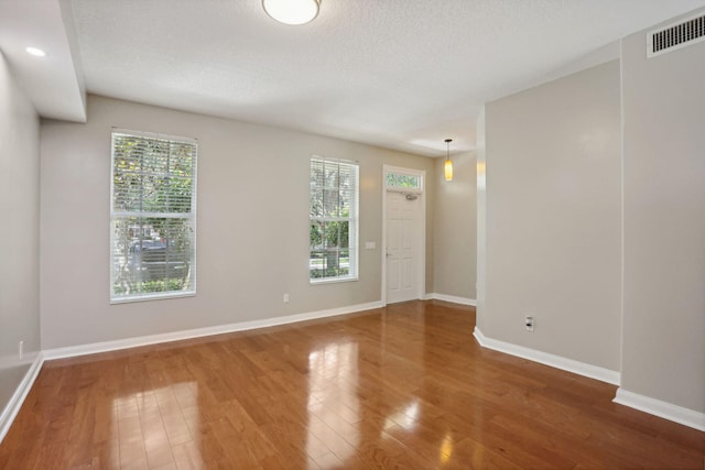 155 Waterford Dr, Jupiter, FL 33458 - empty room with wood finished floors, plenty of natural light, baseboards, and a textured ceiling