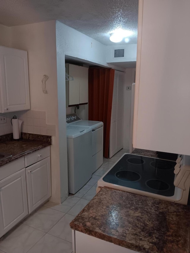 3450 Blue Lake Dr Unit 204, Pompano Beach, FL 33064 - laundry room with visible vents, light tile patterned floors, laundry area, a textured ceiling, and washing machine and dryer