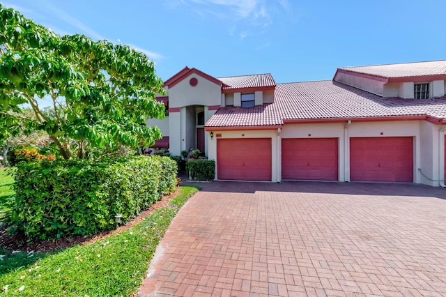 7857 Lexington Club Blvd Unit A, Delray Beach, FL 33446 - mediterranean / spanish-style home featuring a tiled roof, decorative driveway, a garage, and stucco siding