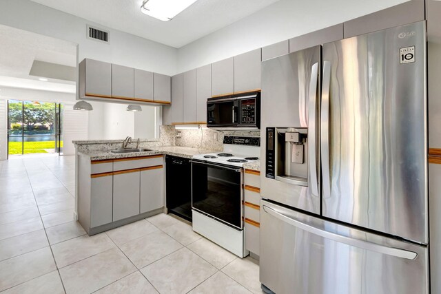 7857 Lexington Club Blvd Unit A, Delray Beach, FL 33446 - kitchen featuring visible vents, gray cabinets, a sink, light tile patterned floors, and black appliances