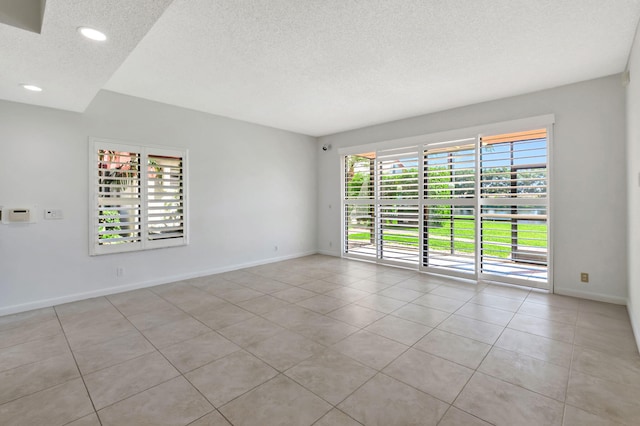 7857 Lexington Club Blvd Unit A, Delray Beach, FL 33446 - empty room featuring light tile patterned floors, baseboards, recessed lighting, and a textured ceiling