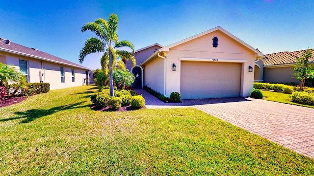 9525 SW Royal Poinciana Dr, Port Saint Lucie, FL 34987 - single story home featuring stucco siding, an attached garage, decorative driveway, and a front lawn