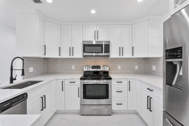 6887 Osborne Dr, Lake Worth, FL 33462 - kitchen with stainless steel appliances, a sink, light marble finish flooring, light stone counters, and recessed lighting