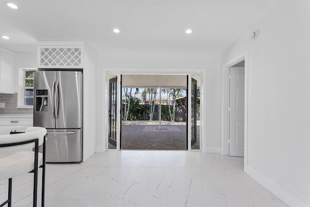 6887 Osborne Dr, Lake Worth, FL 33462 - kitchen featuring stainless steel refrigerator with ice dispenser, recessed lighting, marble tiled flooring, baseboards, and backsplash