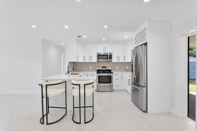 6887 Osborne Dr, Lake Worth, FL 33462 - kitchen with appliances with stainless steel finishes, light marble finish floors, a peninsula, and recessed lighting