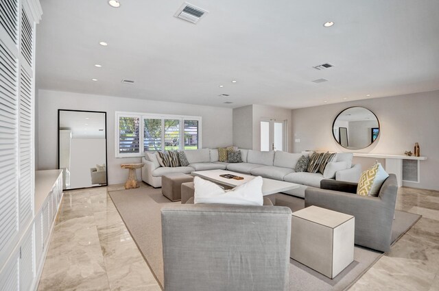 living area with marble finish floor, visible vents, and recessed lighting