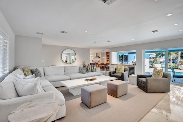 living room featuring marble finish floor, recessed lighting, and visible vents