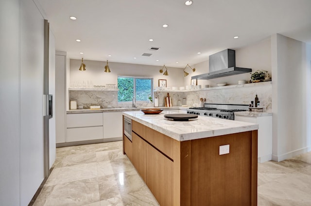 kitchen with marble finish floor, modern cabinets, range, stainless steel microwave, and wall chimney range hood