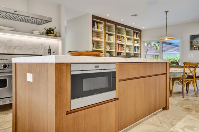 kitchen featuring hanging light fixtures, extractor fan, light countertops, and oven