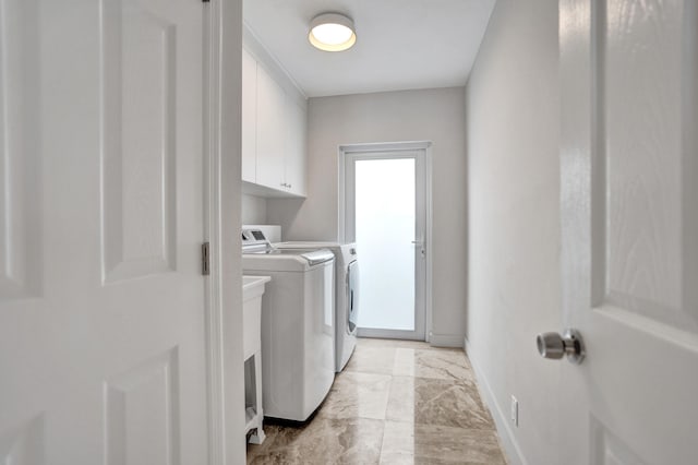 laundry room with marble finish floor, baseboards, washing machine and clothes dryer, and cabinet space