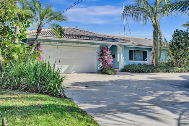 single story home with driveway, a tile roof, an attached garage, and stucco siding