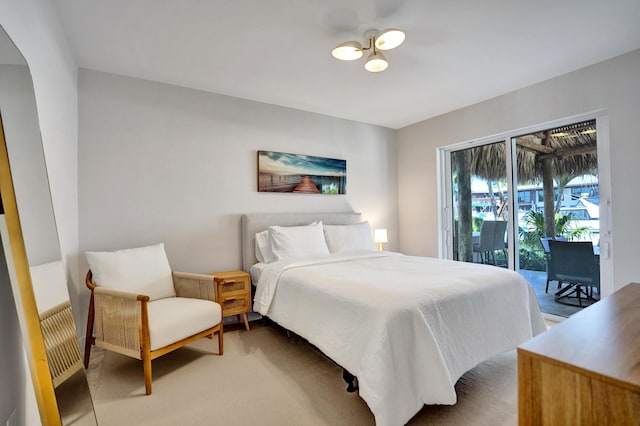 bedroom with light colored carpet, arched walkways, and access to outside