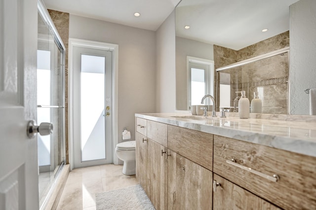 bathroom featuring toilet, a stall shower, recessed lighting, and vanity