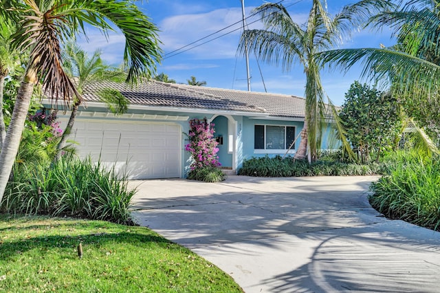 view of front of property with a tile roof, stucco siding, an attached garage, and concrete driveway