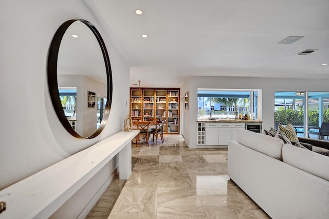 living room with marble finish floor, visible vents, beverage cooler, and recessed lighting
