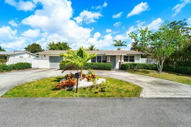 single story home featuring stucco siding, curved driveway, a garage, and fence