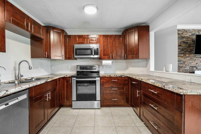 kitchen featuring light stone countertops, appliances with stainless steel finishes, light tile patterned flooring, a textured ceiling, and a sink