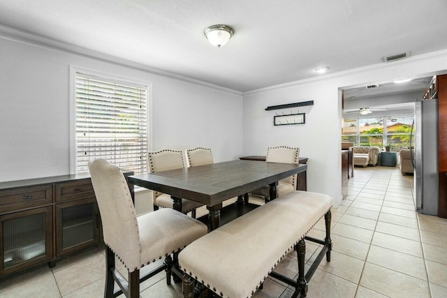 dining space with light tile patterned floors, visible vents, crown molding, and ceiling fan