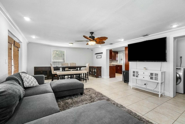 living area with light tile patterned floors, washer / clothes dryer, a ceiling fan, and ornamental molding