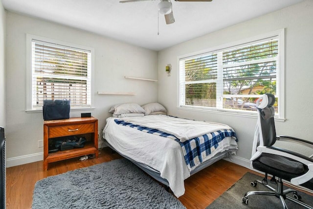 bedroom with ceiling fan, baseboards, and wood finished floors