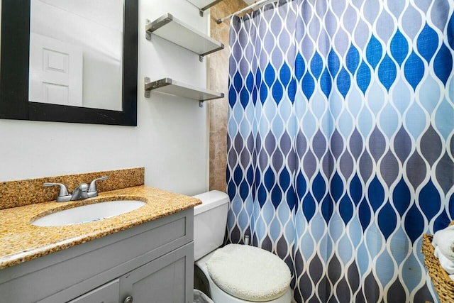 bathroom with a shower with shower curtain, toilet, and vanity