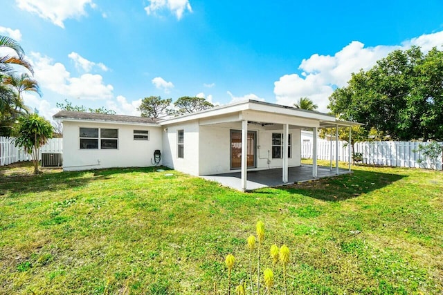 rear view of house with a yard, a patio, and a fenced backyard