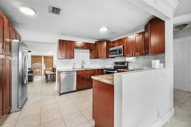 kitchen featuring visible vents, a sink, appliances with stainless steel finishes, a peninsula, and light tile patterned floors