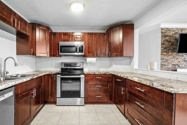 kitchen featuring light stone counters, appliances with stainless steel finishes, light tile patterned flooring, a textured ceiling, and a sink