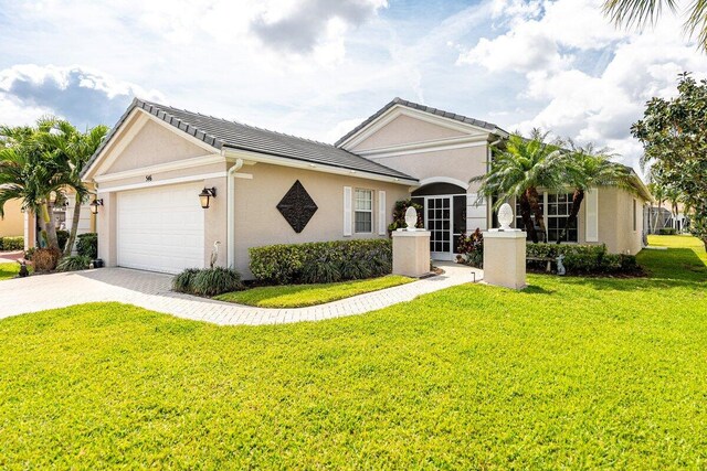view of front of home with stucco siding, an attached garage, a front lawn, and driveway