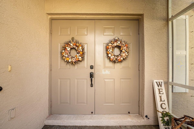 doorway to property featuring stucco siding