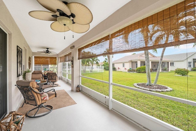 sunroom featuring a residential view and ceiling fan