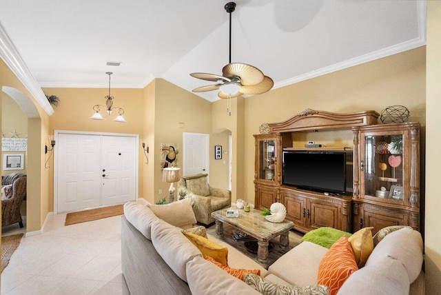 living area featuring lofted ceiling, light tile patterned floors, ornamental molding, arched walkways, and a ceiling fan