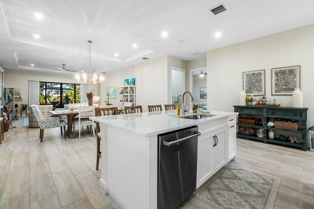 kitchen featuring visible vents, a center island with sink, ceiling fan with notable chandelier, stainless steel dishwasher, and a sink