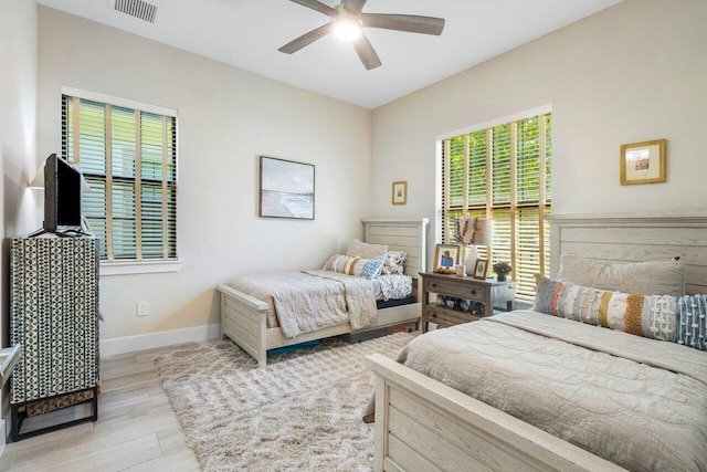 bedroom with visible vents, baseboards, light wood-style floors, and a ceiling fan