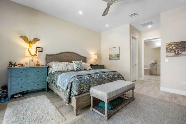 bedroom featuring light wood finished floors, visible vents, connected bathroom, and baseboards