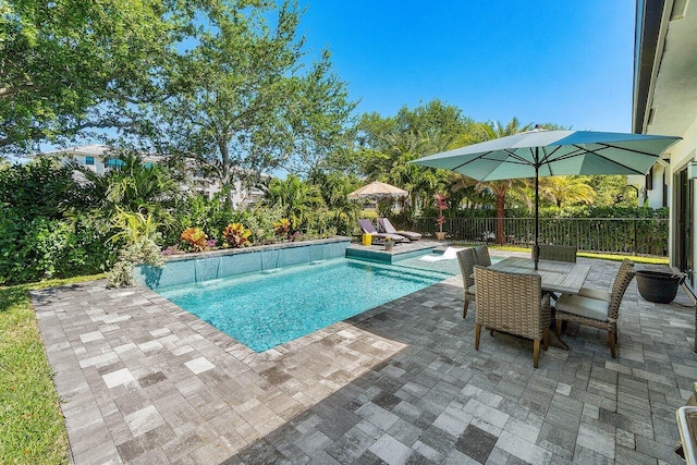 view of pool with outdoor dining space, a patio, a fenced in pool, and fence