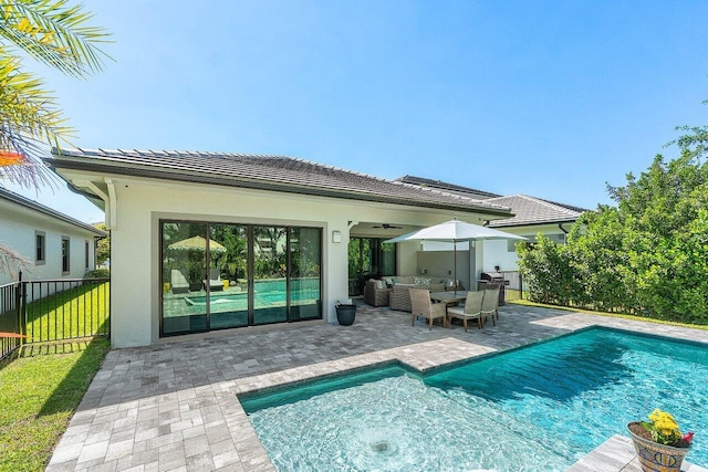 rear view of property with a patio, a fenced in pool, fence, an outdoor living space, and stucco siding