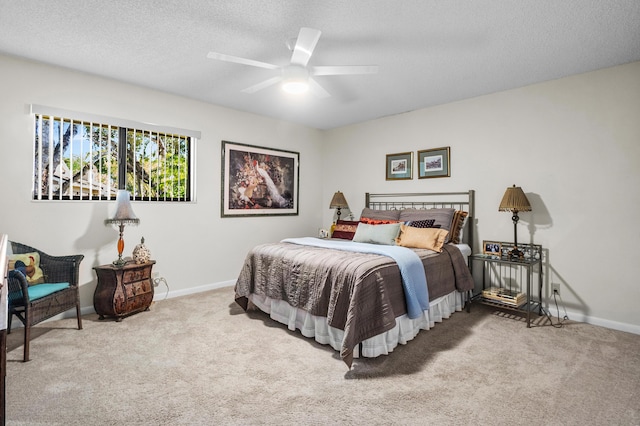 carpeted bedroom with baseboards, ceiling fan, and a textured ceiling