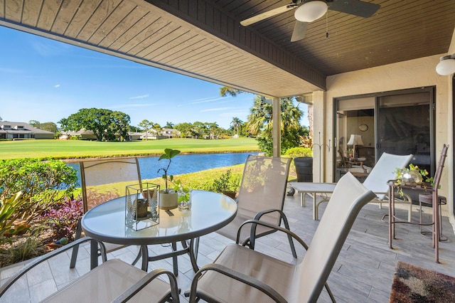 view of patio / terrace featuring outdoor dining area, a water view, and ceiling fan
