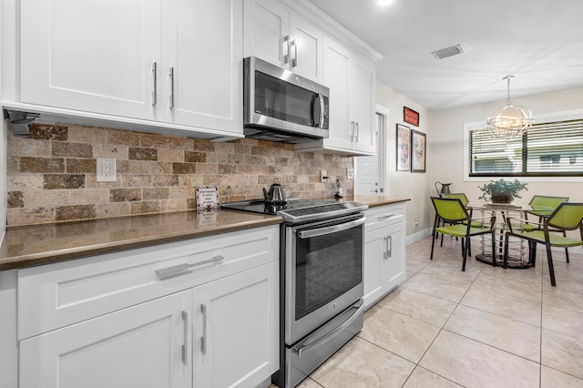 kitchen with light tile patterned flooring, visible vents, appliances with stainless steel finishes, white cabinetry, and backsplash
