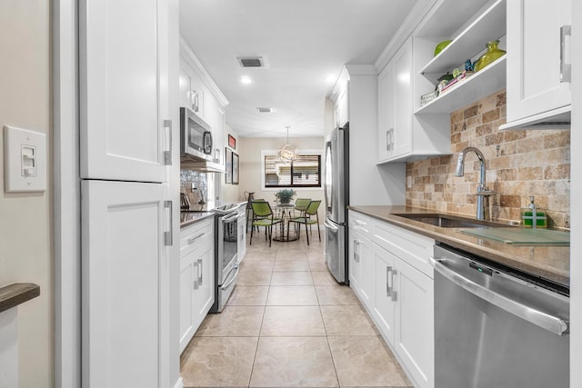 kitchen featuring white cabinets, a sink, stainless steel appliances, and open shelves