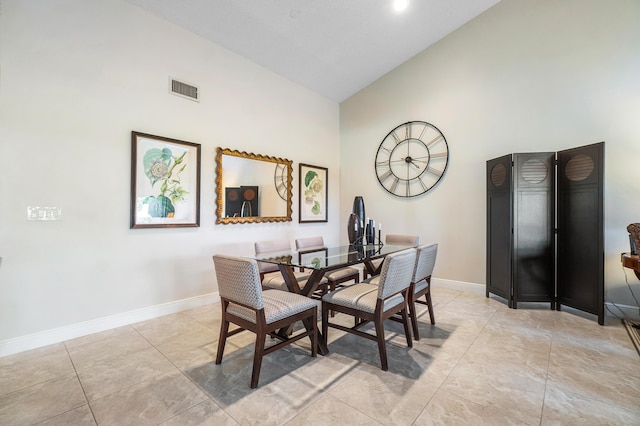 dining space featuring baseboards, visible vents, high vaulted ceiling, and light tile patterned floors