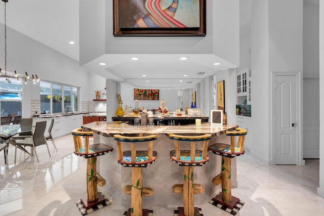 17888 Fieldbrook Cir W, Boca Raton, FL 33496 - indoor wet bar with a towering ceiling, light marble finish flooring, recessed lighting, backsplash, and baseboards