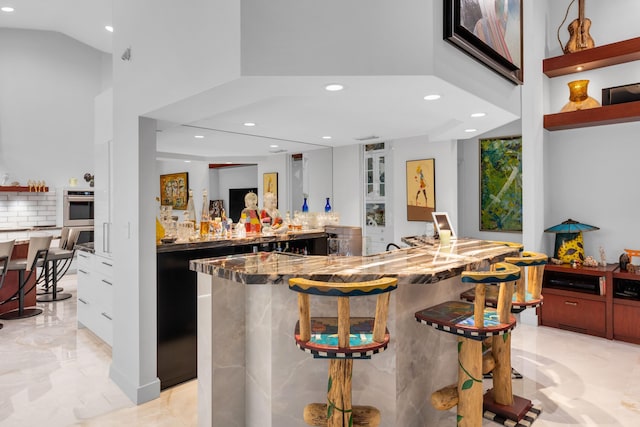 17888 Fieldbrook Cir W, Boca Raton, FL 33496 - indoor wet bar featuring a high ceiling, recessed lighting, light marble finish flooring, double oven, and decorative backsplash