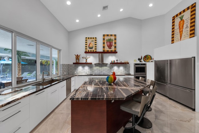 17888 Fieldbrook Cir W, Boca Raton, FL 33496 - kitchen featuring appliances with stainless steel finishes, a sink, light marble finish flooring, lofted ceiling, and modern cabinets