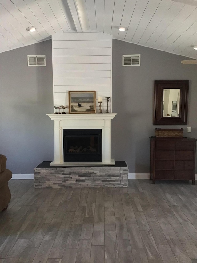 living area with visible vents, baseboards, vaulted ceiling, and a large fireplace