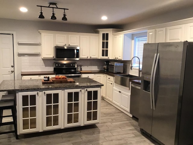 kitchen featuring white cabinets, light wood-style floors, a sink, and appliances with stainless steel finishes