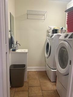 laundry area featuring light tile patterned floors, laundry area, and washing machine and clothes dryer